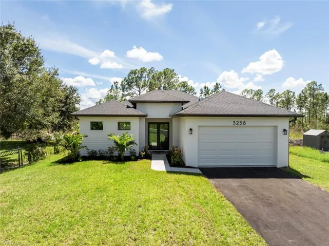 View of front of house featuring a garage and a front lawn