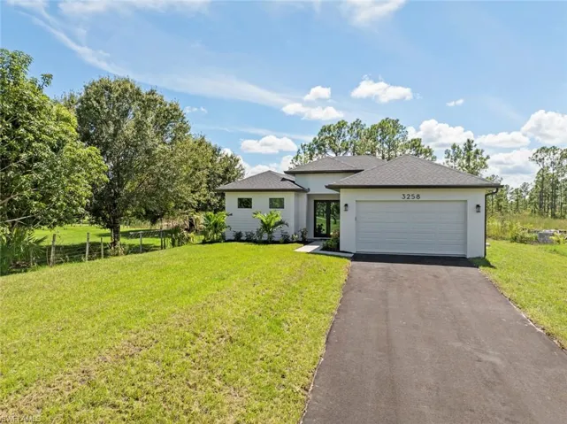 View of front of home with a front yard and a garage