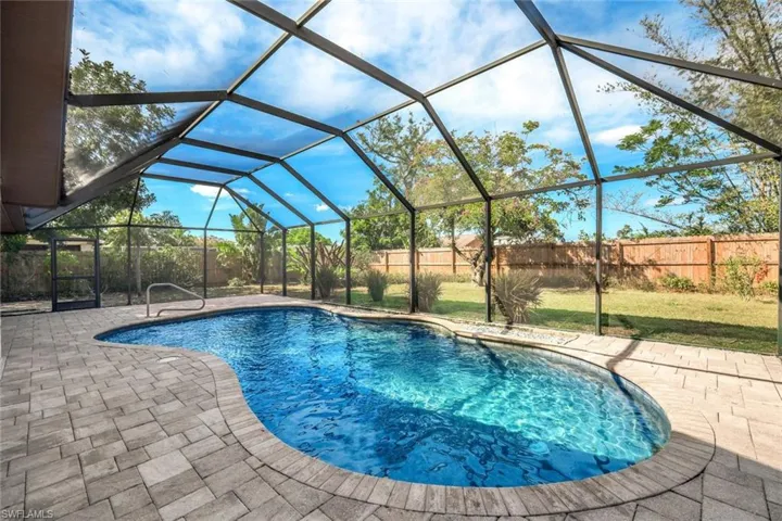 View of swimming pool featuring glass enclosure, a patio, a fenced backyard, and a fenced in pool