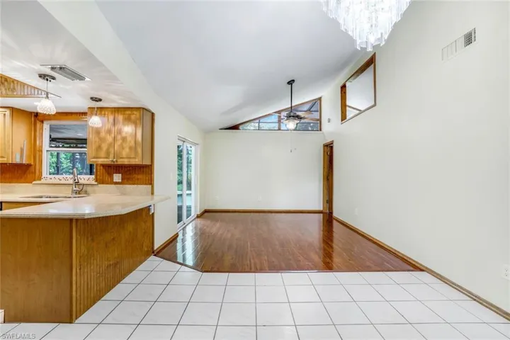 Kitchen with pendant lighting, brown cabinets, light countertops, visible vents, and a sink
