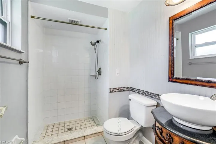 Bathroom featuring visible vents, toilet, a shower stall, vanity, and tile patterned flooring