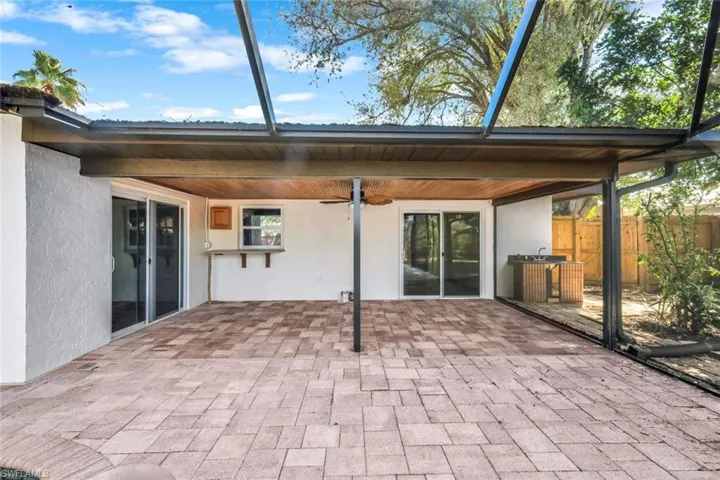 View of patio with fence and a ceiling fan