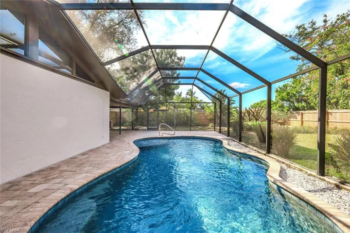 View of pool with glass enclosure, a fenced backyard, a fenced in pool, and a patio