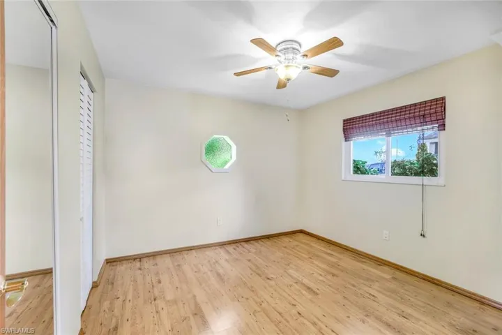 Unfurnished bedroom featuring light wood-style flooring, baseboards, ceiling fan, and a closet