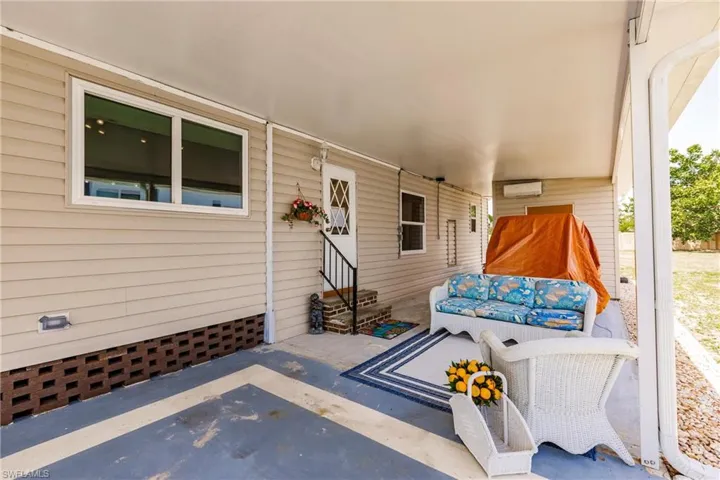 View of patio / terrace with a wall unit AC and entry steps