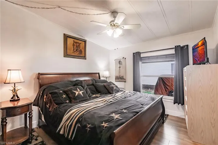 Bedroom featuring baseboards, ceiling fan, vaulted ceiling, and laminate floors