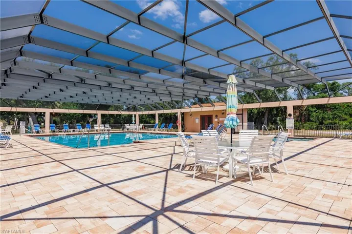 Fully screened-in community pool featuring spa