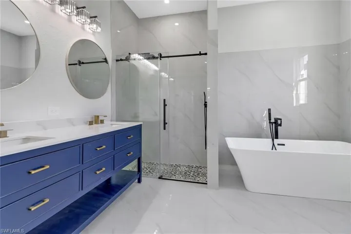 Bathroom featuring tile walls, vanity, and independent shower and bath