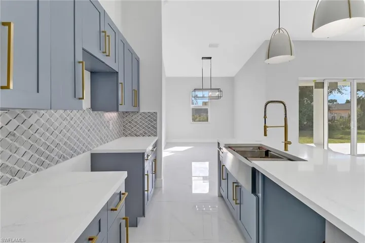 Kitchen featuring sink, a wealth of natural light, decorative backsplash, and decorative light fixtures