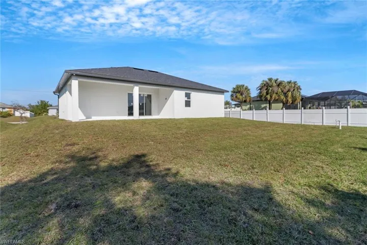 Rear view of house featuring a lawn