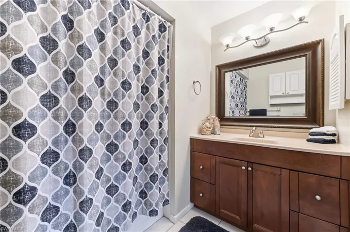 Full bathroom featuring tub and shower with tile flooring.