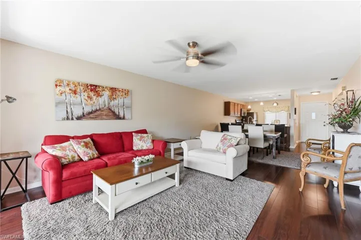 Living area with a ceiling fan and hardwood flooring throughout