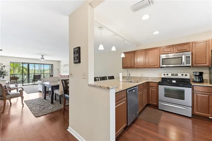 Kitchen with stainless steel appliances, updated cabinets, quartz countertops, and updated hardwood flooring
