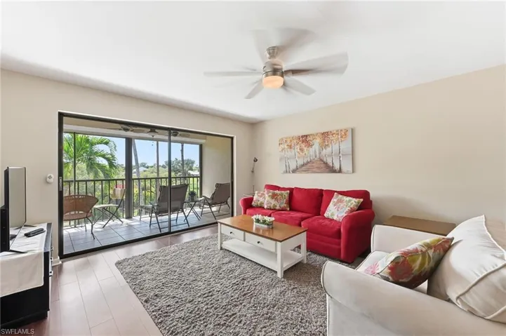 Living room featuring ceiling fan and hardwood floors with access to the tiled lanai