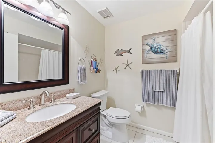 Full bathroom with vanity, light tile floors, and tiled shower