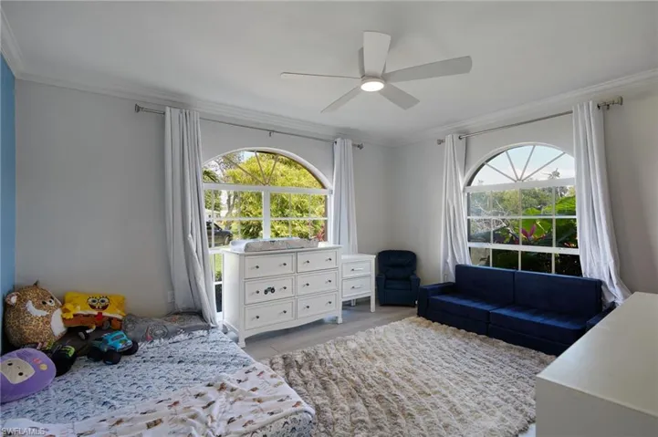 Bedroom featuring ceiling fan and ornamental molding