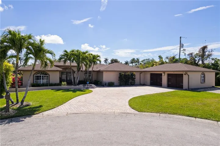 Single story home with a front lawn, decorative driveway, and stucco siding