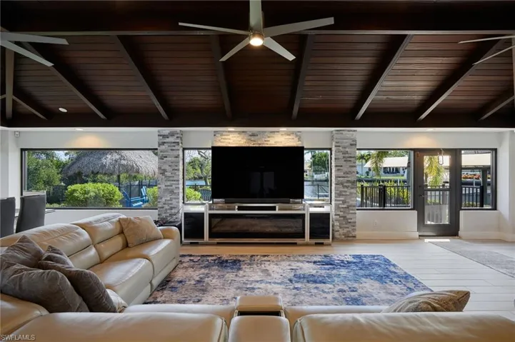 Living room with wood ceiling, a healthy amount of sunlight, lofted ceiling with beams,