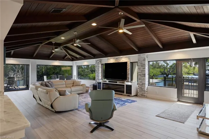 Living room with a wealth of natural light, beam ceiling,