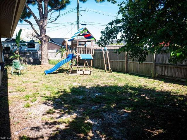 Large backyard featuring a playground