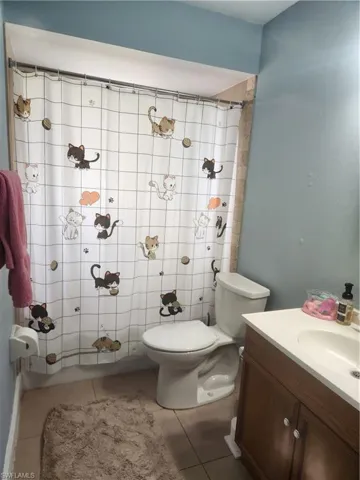 Full bathroom with vanity, light tile patterned flooring, and a shower