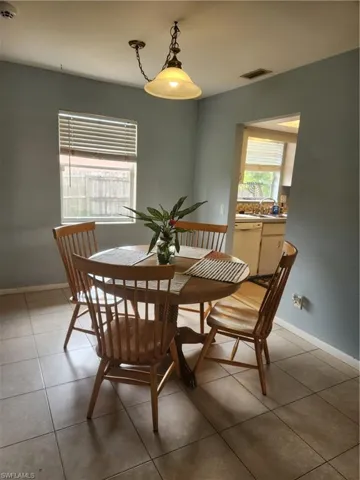 Dining area with light tile patterned flooring and baseboards