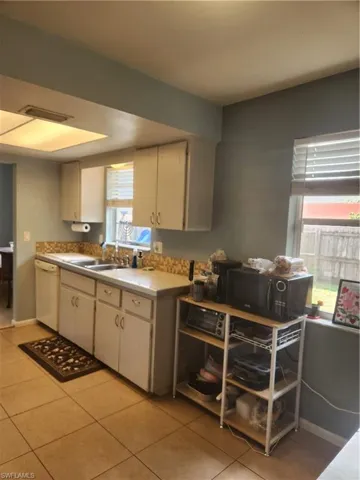 Kitchen featuring light countertops, white cabinets, and updated appliances.