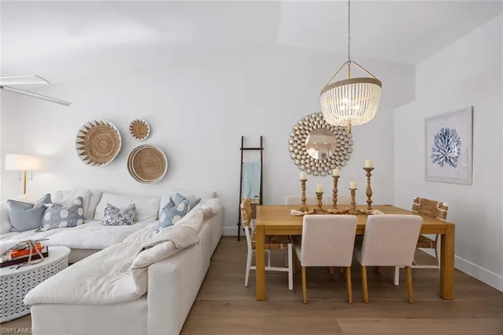 Dining space featuring light wood-type flooring, a chandelier, and lofted ceiling
