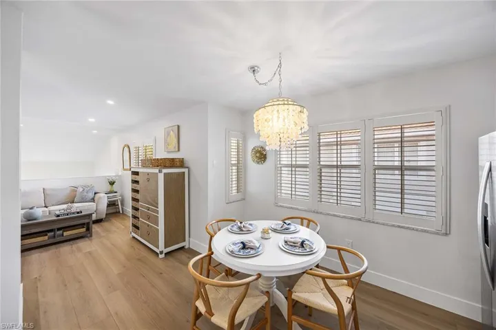 Dining space with light wood-style flooring, a chandelier, recessed lighting, and vaulted ceiling