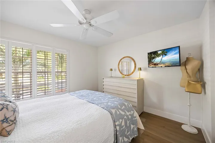 Bedroom with dark wood-style floors and ceiling fan