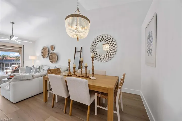 Dining space featuring light wood-type flooring, a ceiling fan, and a chandelier