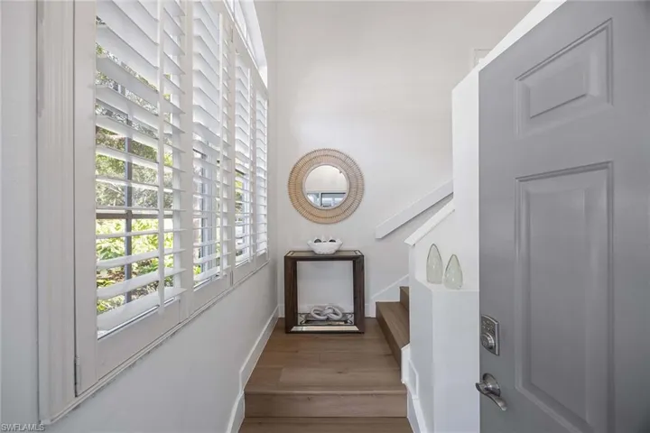 Stairway with wood finished floors and baseboards