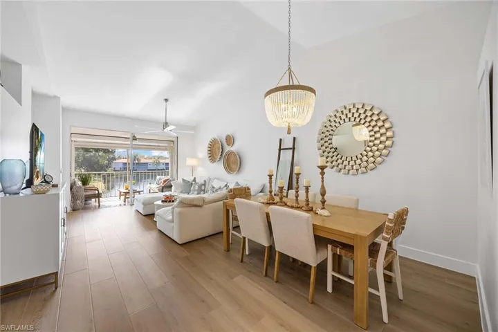 Dining area featuring ceiling fan, light wood-style floors, and a chandelier