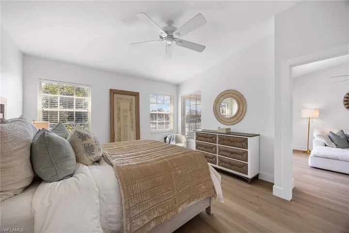 Bedroom featuring wood finished floors, multiple windows, and a ceiling fan