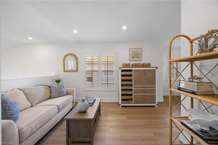 Living area with light wood finished floors and recessed lighting