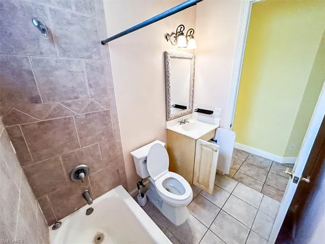 Full bathroom with tile patterned flooring, vanity, toilet, and tiled shower / bath