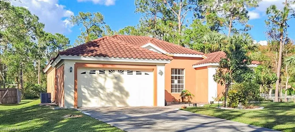 Mediterranean / spanish-style home featuring a garage and a front lawn
