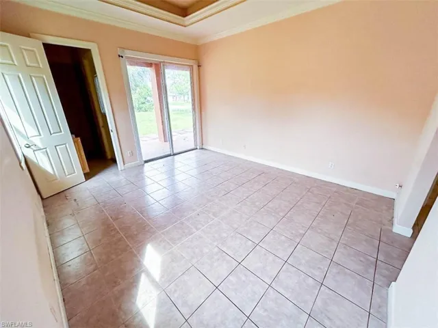 Tiled empty room featuring ornamental molding