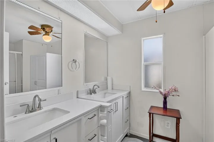Double vanity featuring white cabinetry and countertops