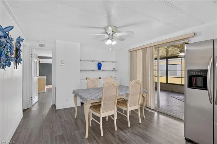 Dining area with wood-finish flooring, built-in shelving, and white paneled walls