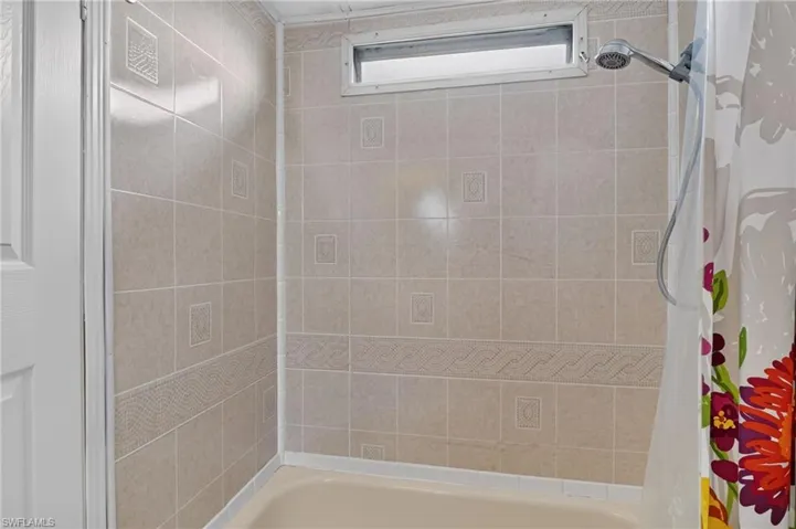 Bathtub with ceramic tile surround featuring decorative accents