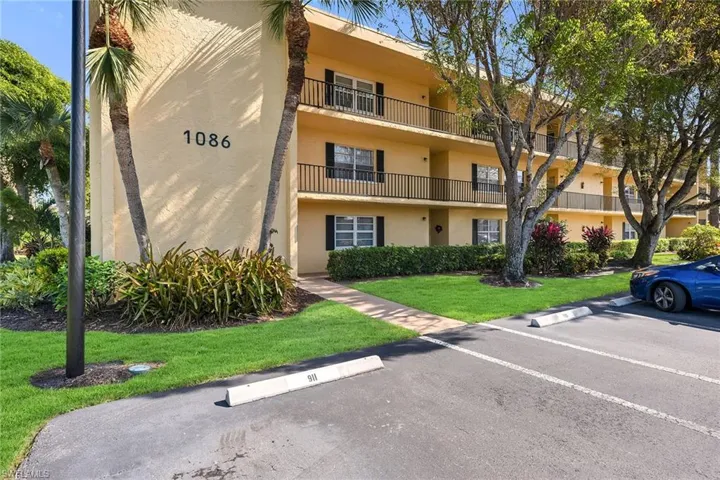 View of apartment building / complex with uncovered parking
