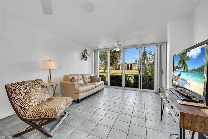 Living room featuring light tile patterned floors and ceiling fan