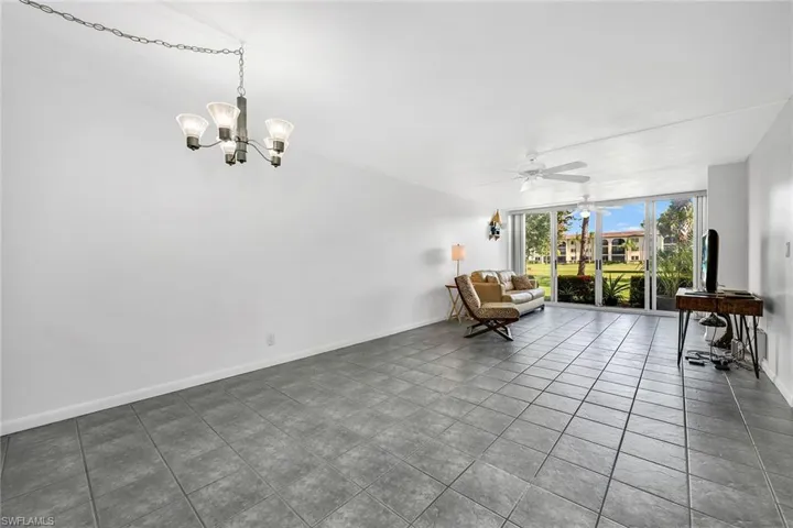 Sitting room featuring a wall of windows, ceiling fan, and tile patterned floors