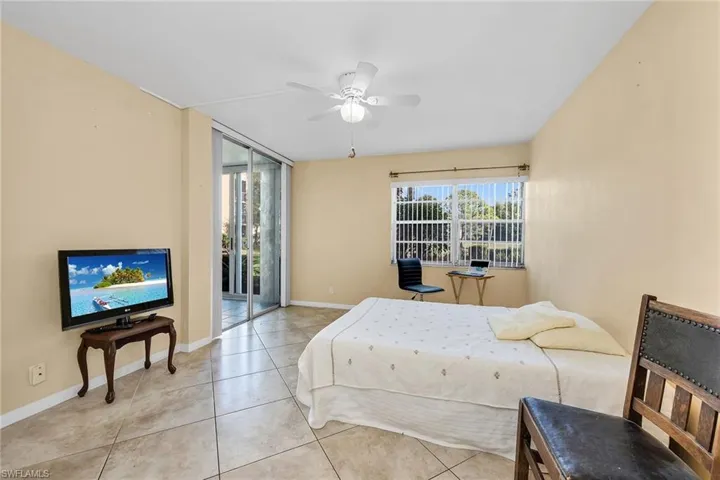 Tiled bedroom featuring access to outside and a ceiling fan