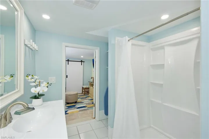 Bathroom featuring recessed lighting, light tile patterned floors, vanity, and a shower with curtain - Virtually Edited Image