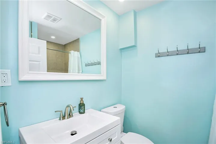 Bathroom with vanity, a shower with shower curtain, and recessed lighting - Virtually Edited Image