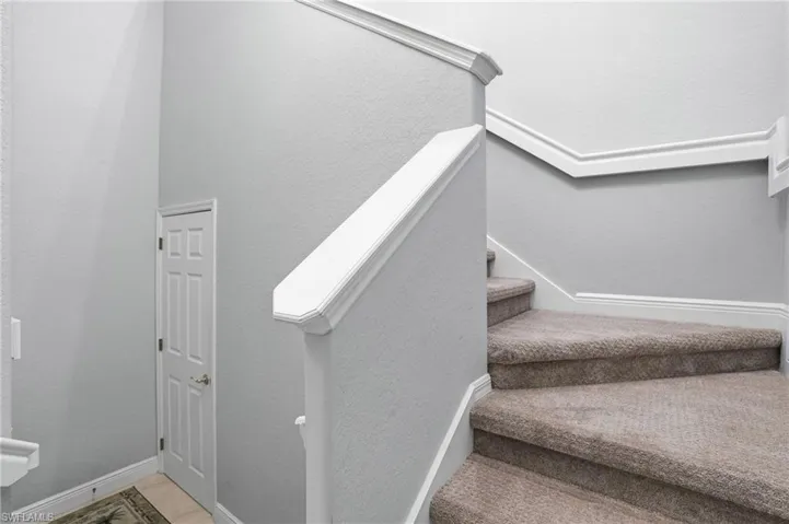 Staircase featuring a textured wall