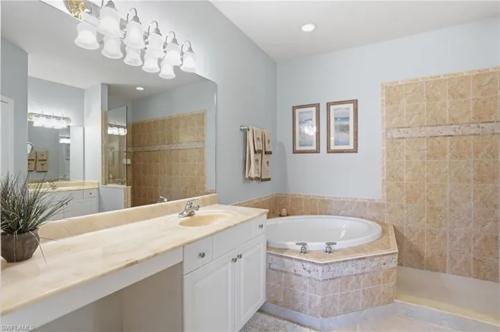Full bath featuring a walk in shower, vanity, and a bath