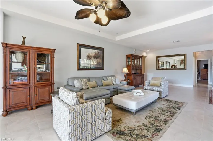 Living room with a ceiling fan and a tray ceiling
